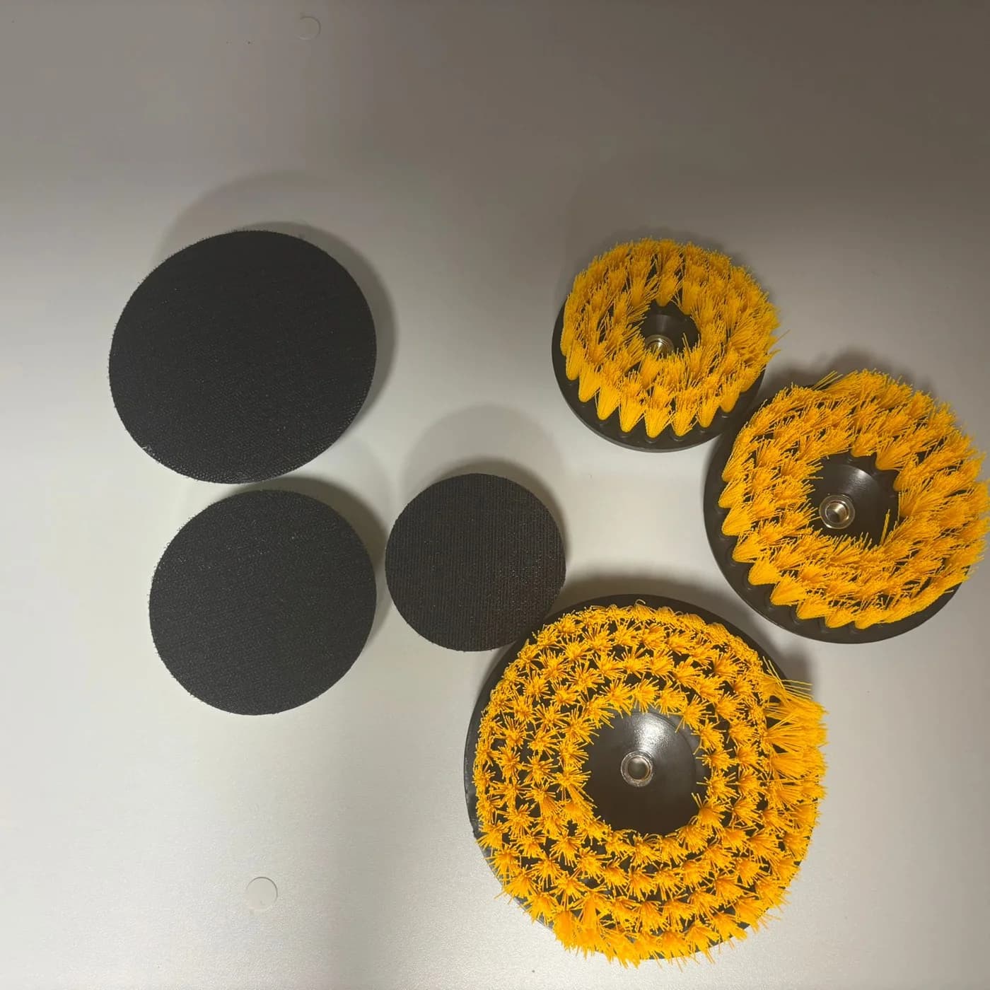 The six interchangeable heads: three brushes of different sizes and three pads