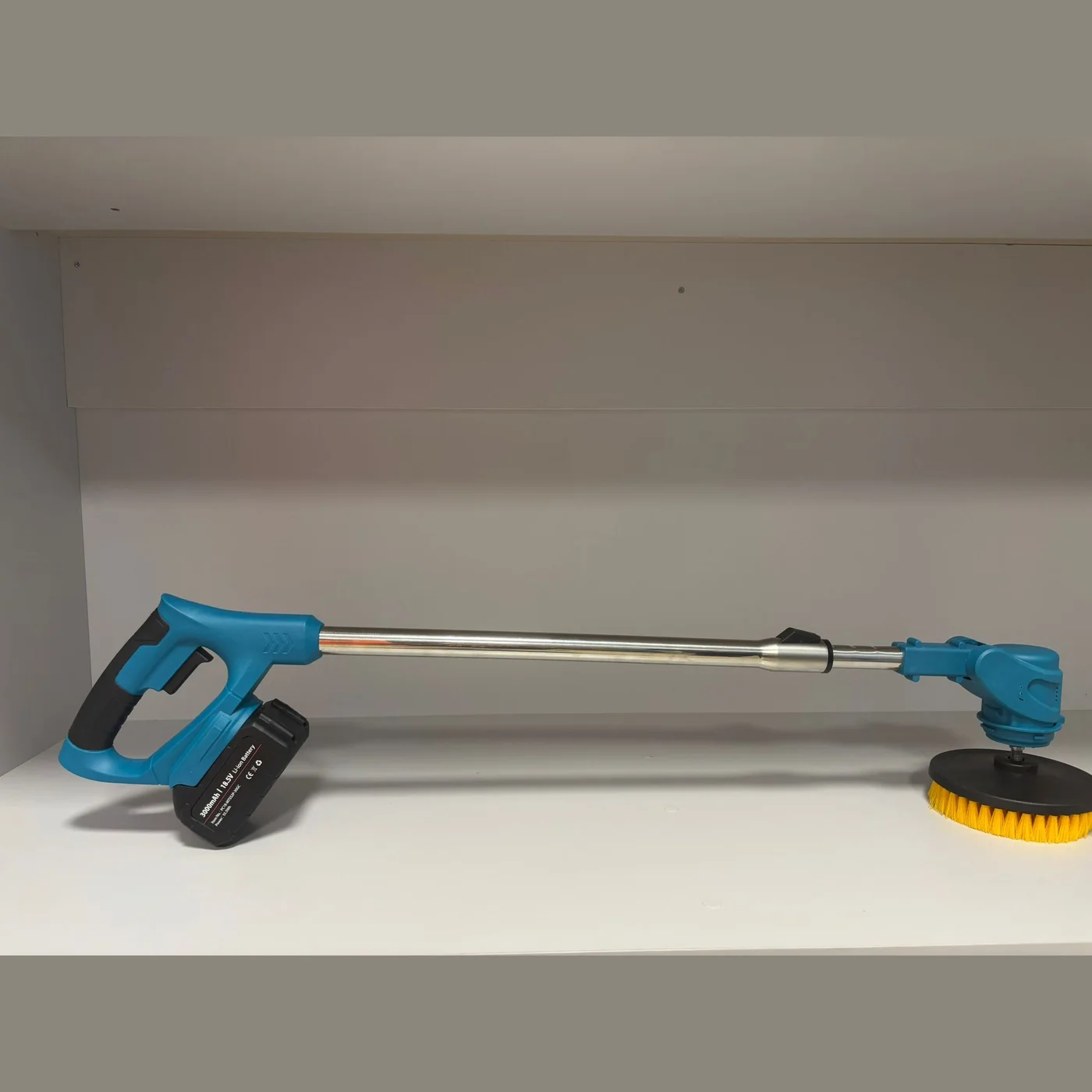 Spin scrubber with the telescopic handle extended, seen at an angle