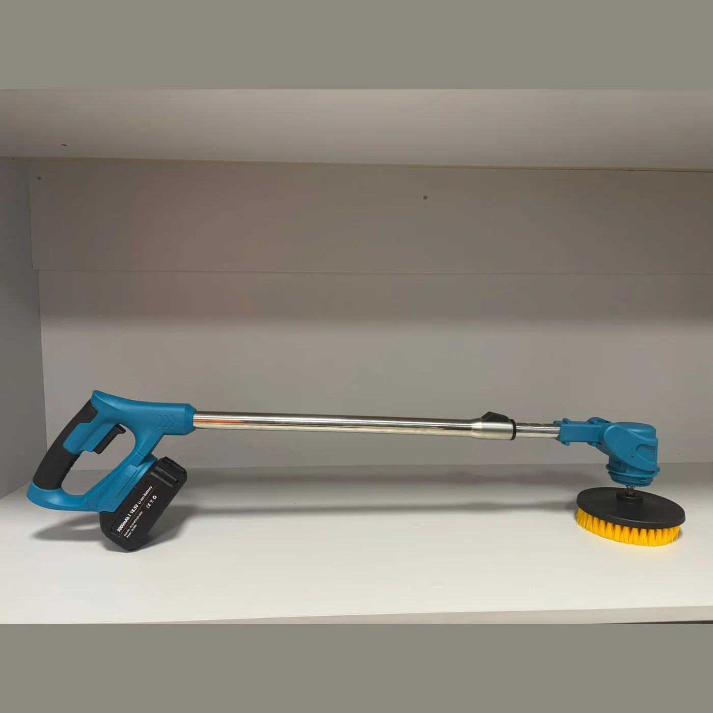Cordless spin scrubber assembled, with battery and a round brush on the head
